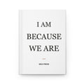 White hardcover journal with “I Am Because We Are” in black serif type and a rust accent rule — Iska Press, WE ARE Drop 01